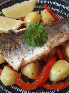 Una foto de Lubina a la plancha con patatas, guindilla y limón