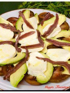 Una foto de Ensalada de tomate, aguacate, mozzarella y anchoas