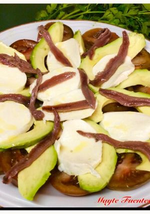 Una foto de Ensalada de tomate, aguacate, mozzarella y anchoas