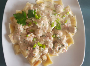 Una foto de Ravioles, con salsa de champiñones y jamón