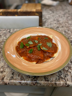 A picture of Homemade Ricotta Ravioli with Sunday Sauce.