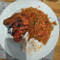 Jollof rice with coleslaw and fried chicken A picture of Jollof rice with coleslaw and fried chicken.