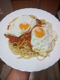 Una foto de Pasta con boloñesa de salchicha con huevos fritos