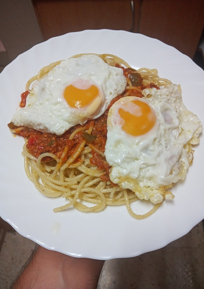 Una foto de Pasta con boloñesa de salchicha con huevos fritos