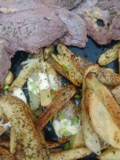 Una foto de Bifes con papas al horno condimentadas