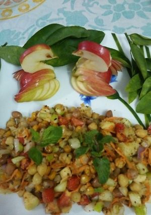 A picture of Chickpea fruits veggies and nuts salad.
