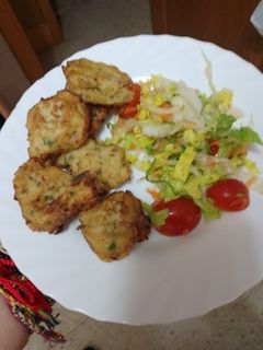 Una foto de Buñuelos de puré de papas, abadejo, palitos de cangrejo y cebolla sofrita con ensalada