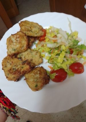 Una foto de Buñuelos de puré de papas, abadejo, palitos de cangrejo y cebolla sofrita con ensalada