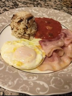 Una foto de Huevo frito con bacon, arroz y tomate con hortalizas
