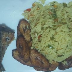 Fried rice with fried plantain and fried fish A picture of Fried rice with fried plantain and fried fish.