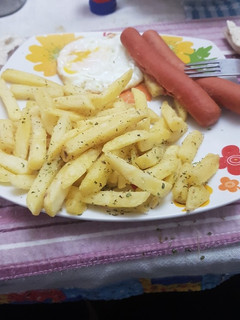 Una foto de Papas fritas con huevo y salchichas