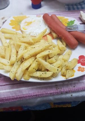 Una foto de Papas fritas con huevo y salchichas