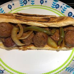 A picture of Bite Sized Baked Sausages with Peppers and Onions.