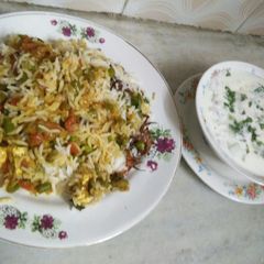 A picture of Veg Hyderabadi biryani with raita.