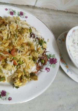 A picture of Veg Hyderabadi biryani with raita.