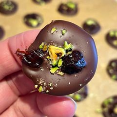 A picture of Dark Chocolate Buttons With Sour Cherry & Pistachio 🍒.
