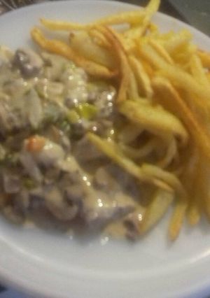 Una foto de Bifes con salsa de Champignones acompañado de papas fritas