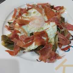Una foto de Huevo con alcachofas y jamón