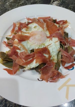 Una foto de Huevo con alcachofas y jamón