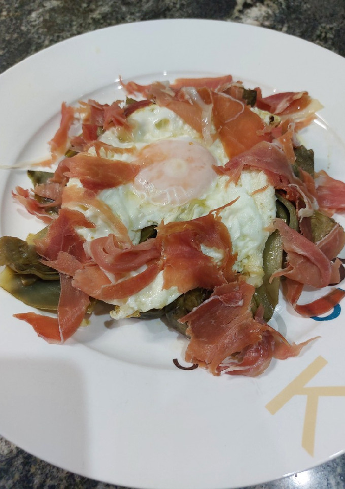 Una foto de Huevo con alcachofas y jamón