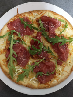 Una foto de Pizza de bresaola y rúcula