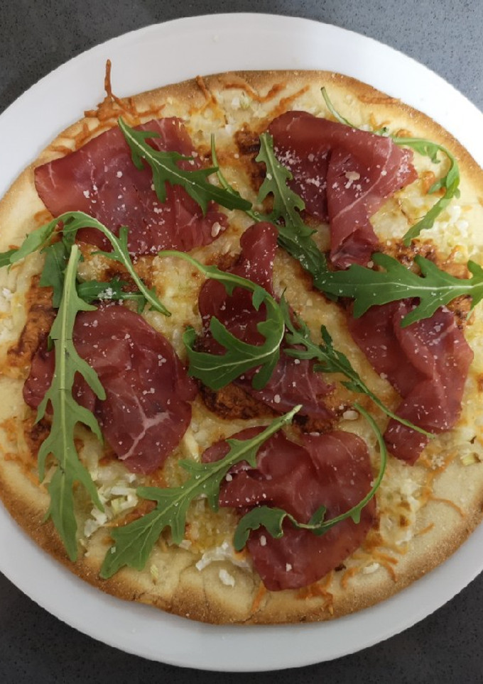 Una foto de Pizza de bresaola y rúcula