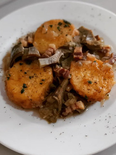 Una foto de Patatas a la importancia con alcachofas y panceta ibérica