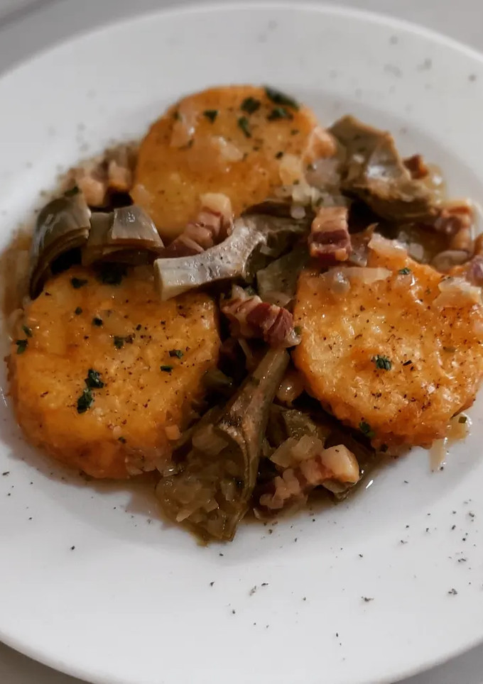 Una foto de Patatas a la importancia con alcachofas y panceta ibérica