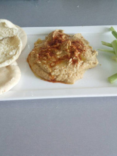 Una foto de Hummus casi clásico, acompañado de pan de pita
