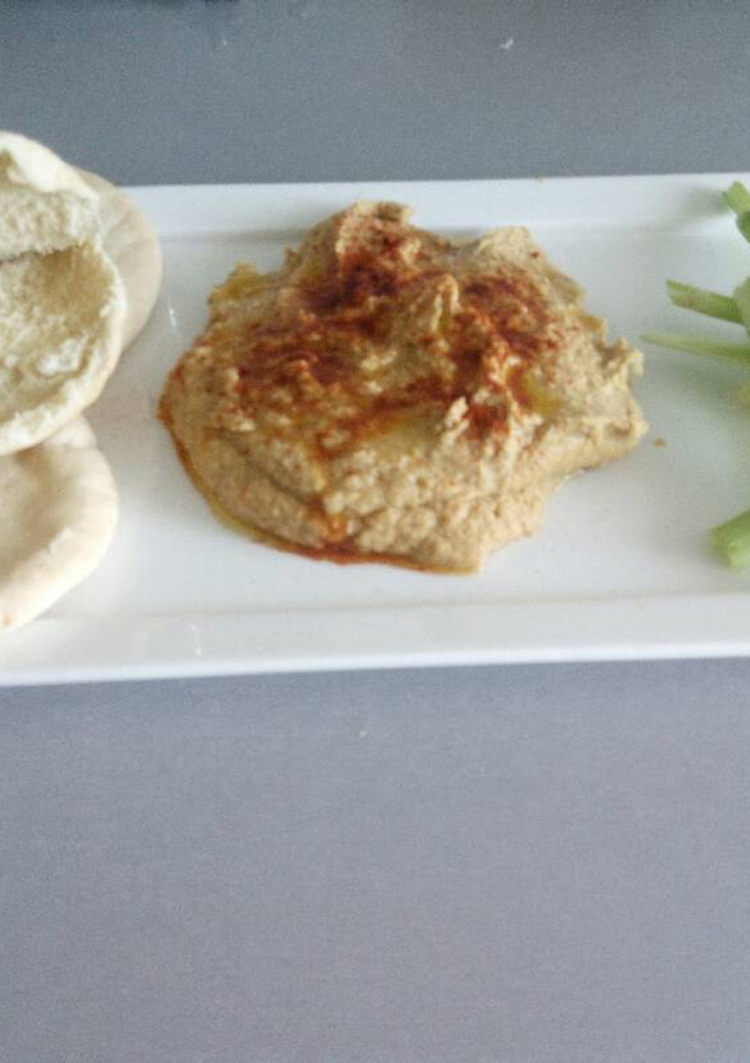 Una foto de Hummus casi clásico, acompañado de pan de pita