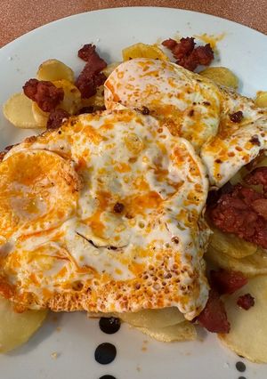 Una foto de Huevos fritos con patatas y chorizo desmenuzado
