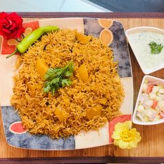 A picture of Patato rice with raita and salad.