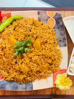 A picture of Patato rice with raita and salad.