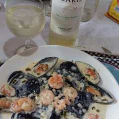 Una foto de Sorrentinos de salmón con tinta de calamar y salsa camarón