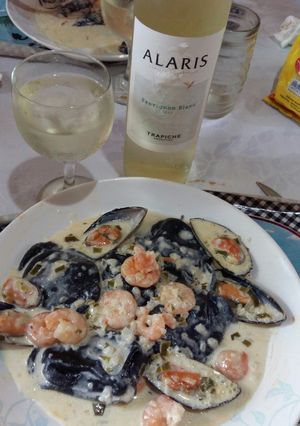 Una foto de Sorrentinos de salmón con tinta de calamar y salsa camarón
