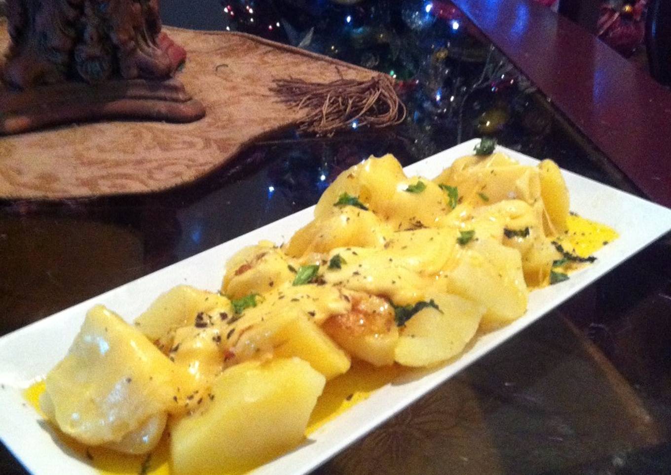 Papas a la mantequilla de ajo con queso gruyer derretido.