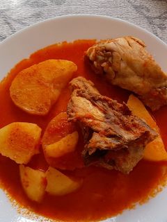Una foto de Pollo con patatas guisadas en salsa de pimientos rojos