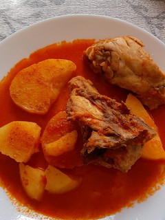 Una foto de Pollo con patatas guisadas en salsa de pimientos rojos