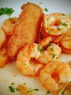 Una foto de Langostinos al ajillo con pan frito
