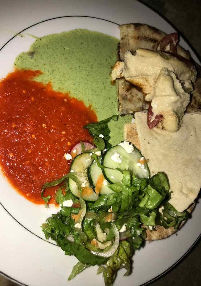 A picture of Gurasa with salad and tomato stew with cucumber.