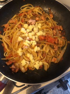Una foto de Fideos salteados con cebolla, tomate, jamón y panceta