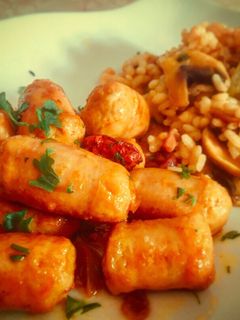 Una foto de Longaniza de pollo al ajillo y vino con guarnición en su jugo