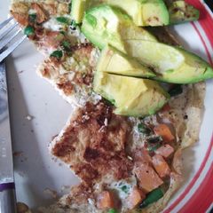 A picture of Fried eggs with vegetables and avocado.