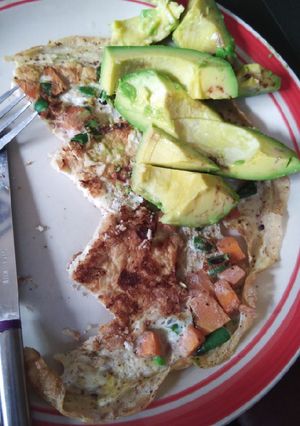 A picture of Fried eggs with vegetables and avocado.