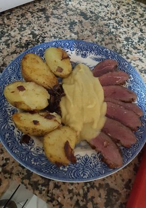 Una foto de Magret de pato con puré de manzana y patatas con cebolla Romero