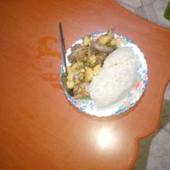 A picture of Fried rice served with chicken stew.