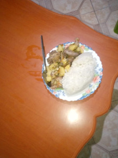 A picture of Fried rice served with chicken stew.