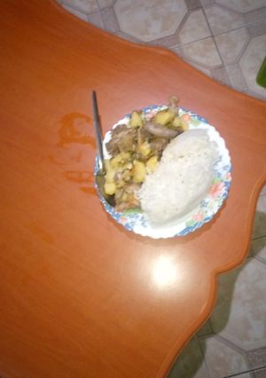 A picture of Fried rice served with chicken stew.