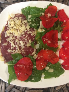 Una foto de Carpaccio con pétalos de amapola y diente de león