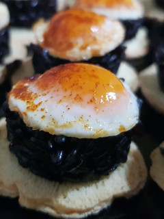Una foto de Arroz negro Venere con huevo de codorniz